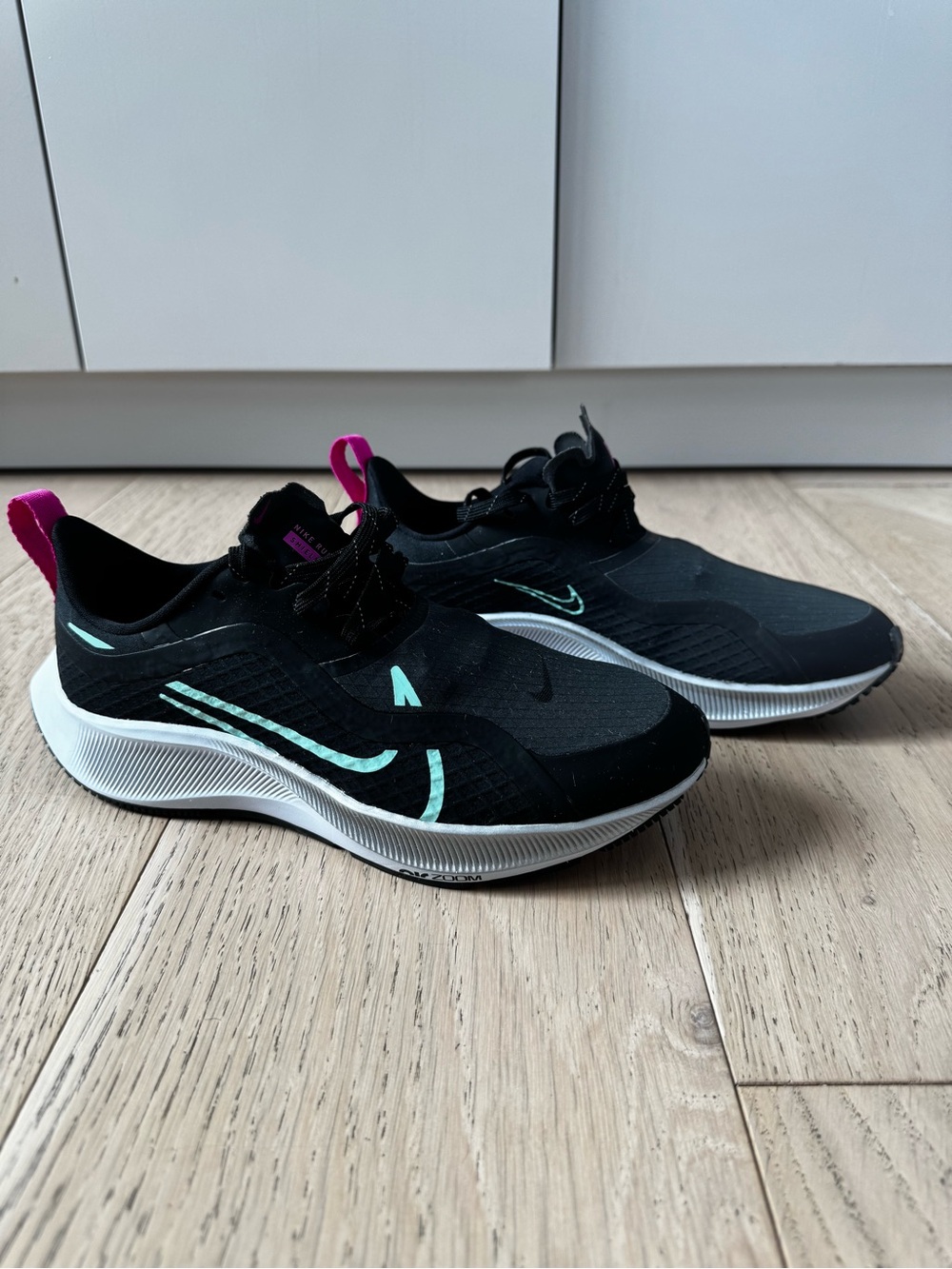 Nike Women’s Black Sneakers with Teal Accents and Pink Pull Tabs